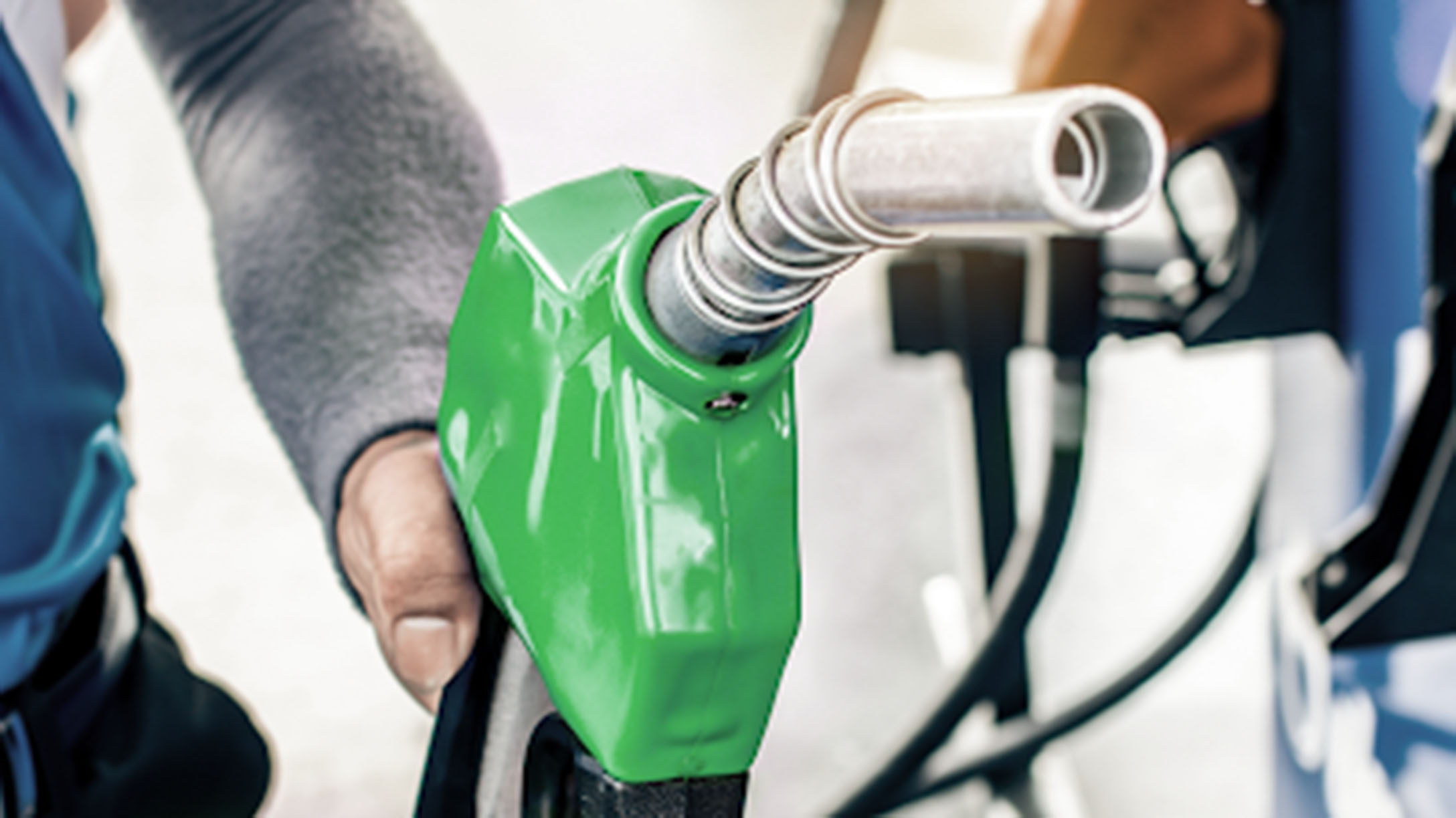 A green nozzle filling up a truck. 