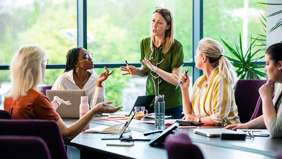 Picture of 5 different women having a discussion at a table