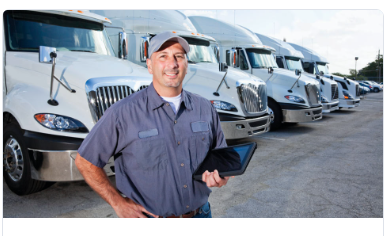person smiling with fleet of trucks behind him