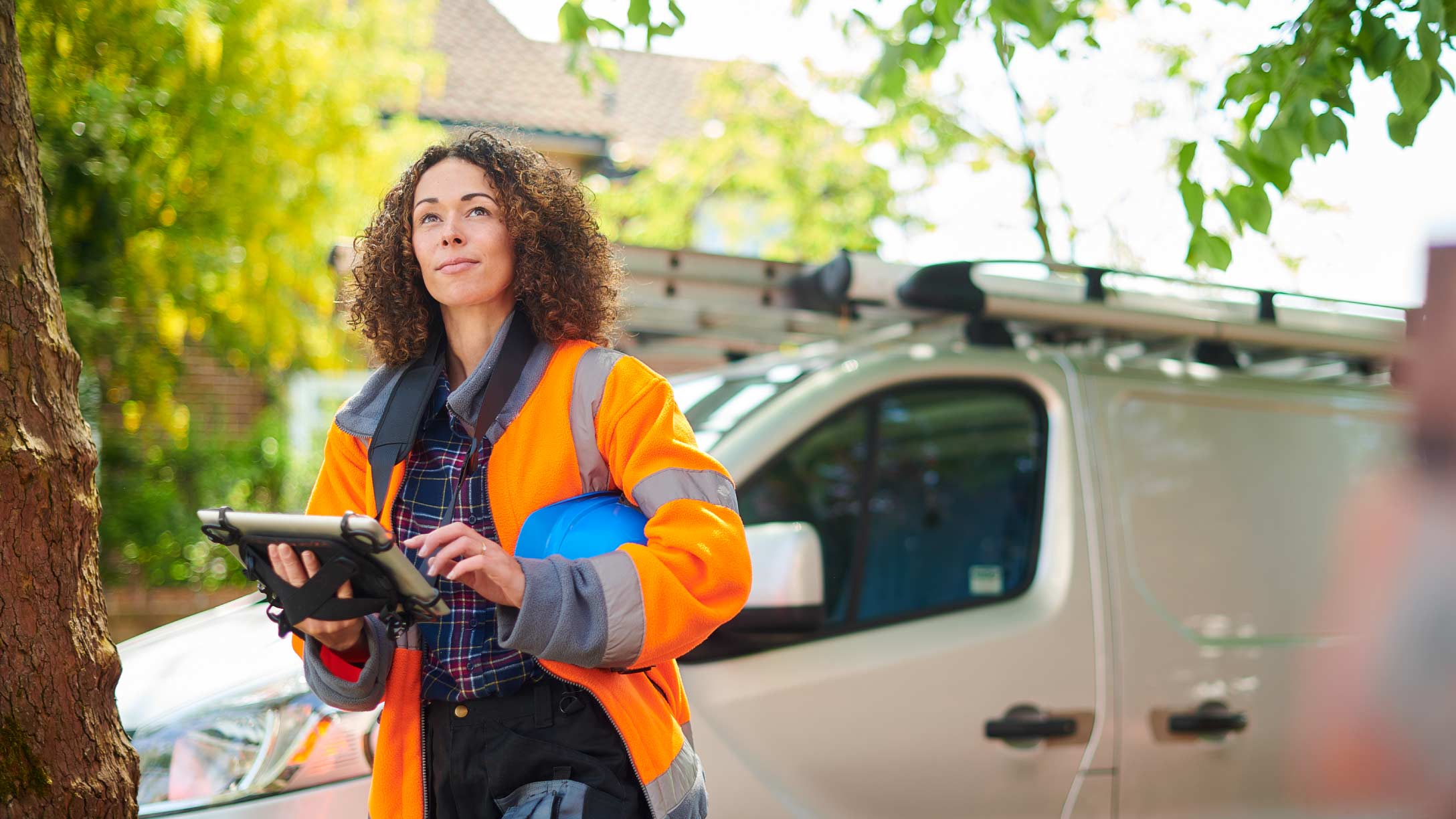 Woman standing infront of light duty vehicle holding a clipboard