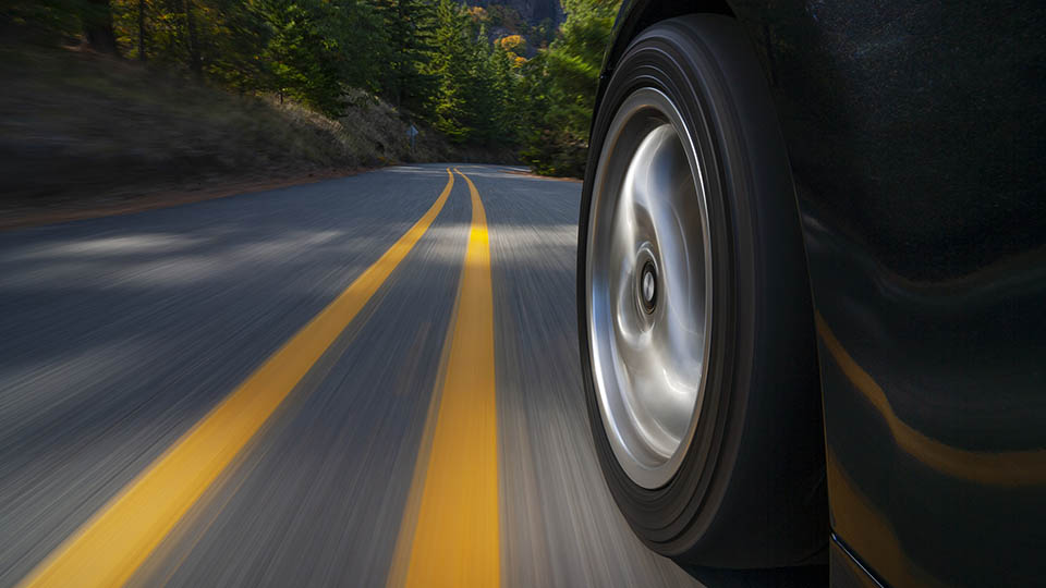 car driving down road side view with yellow stripes on road