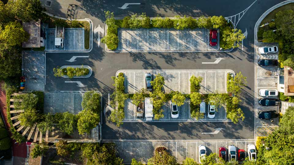 overhead view of a parking lot with bushes around the spaces