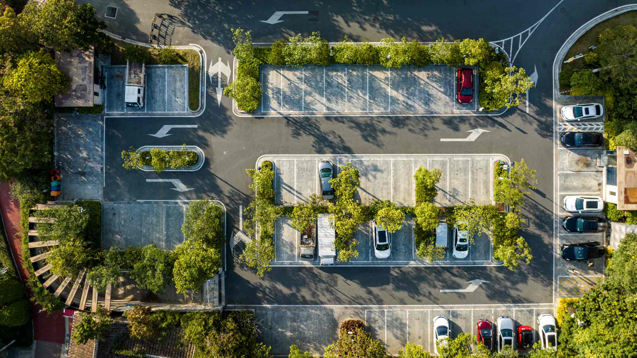 overhead view of a parking lot with bushes around the spaces