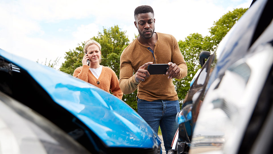 person taking a picture of a collision of two vehicles