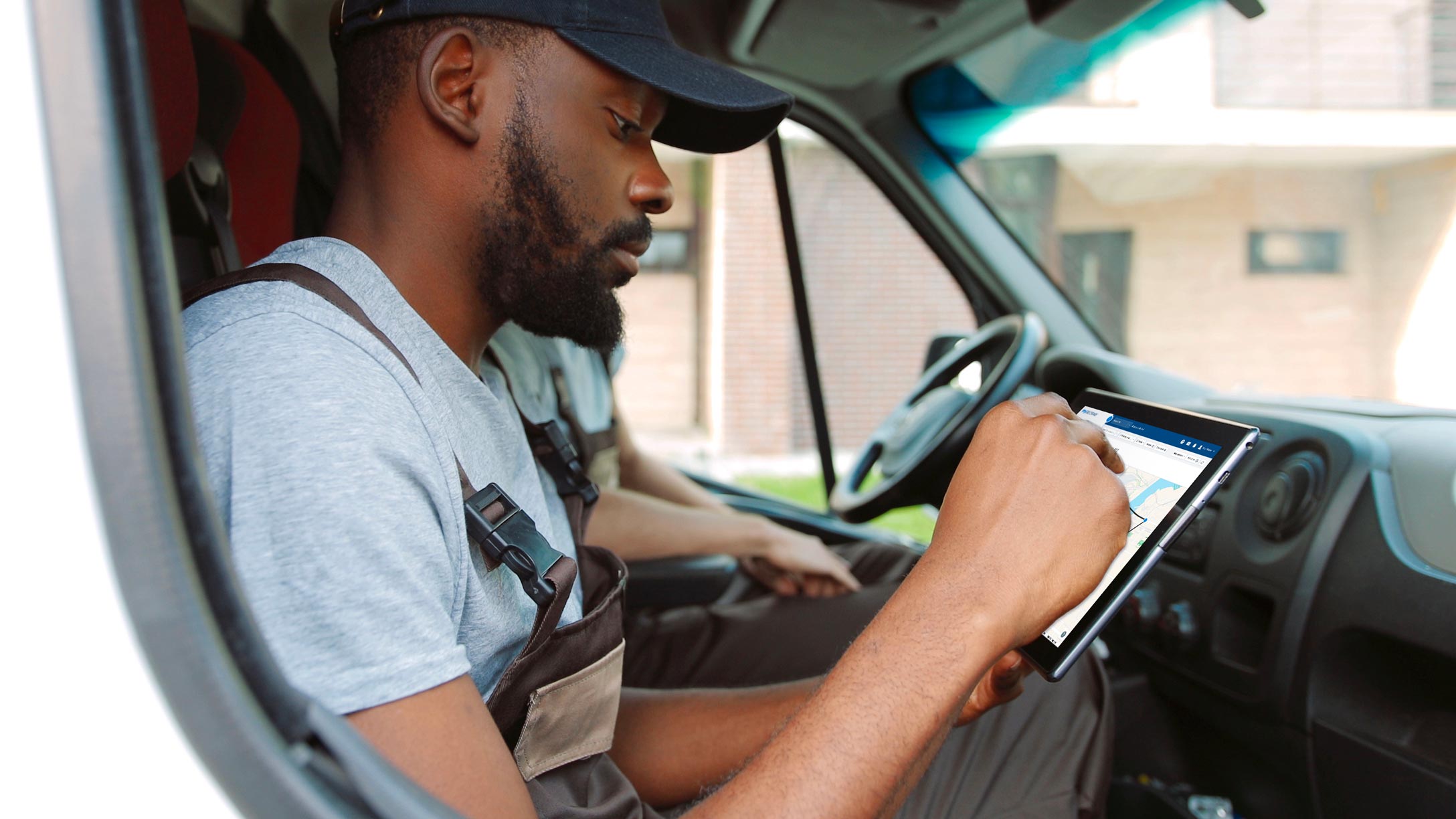 man using tablet in parked vehicle