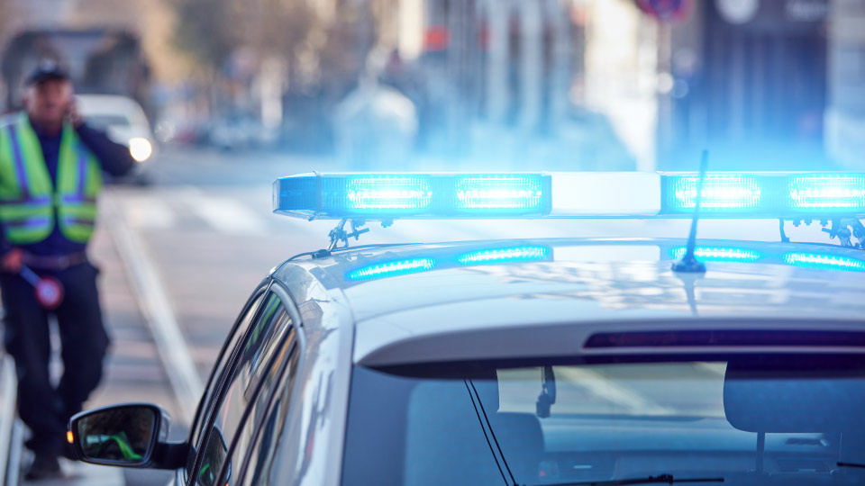 Police car with lights on parked on the side of the road