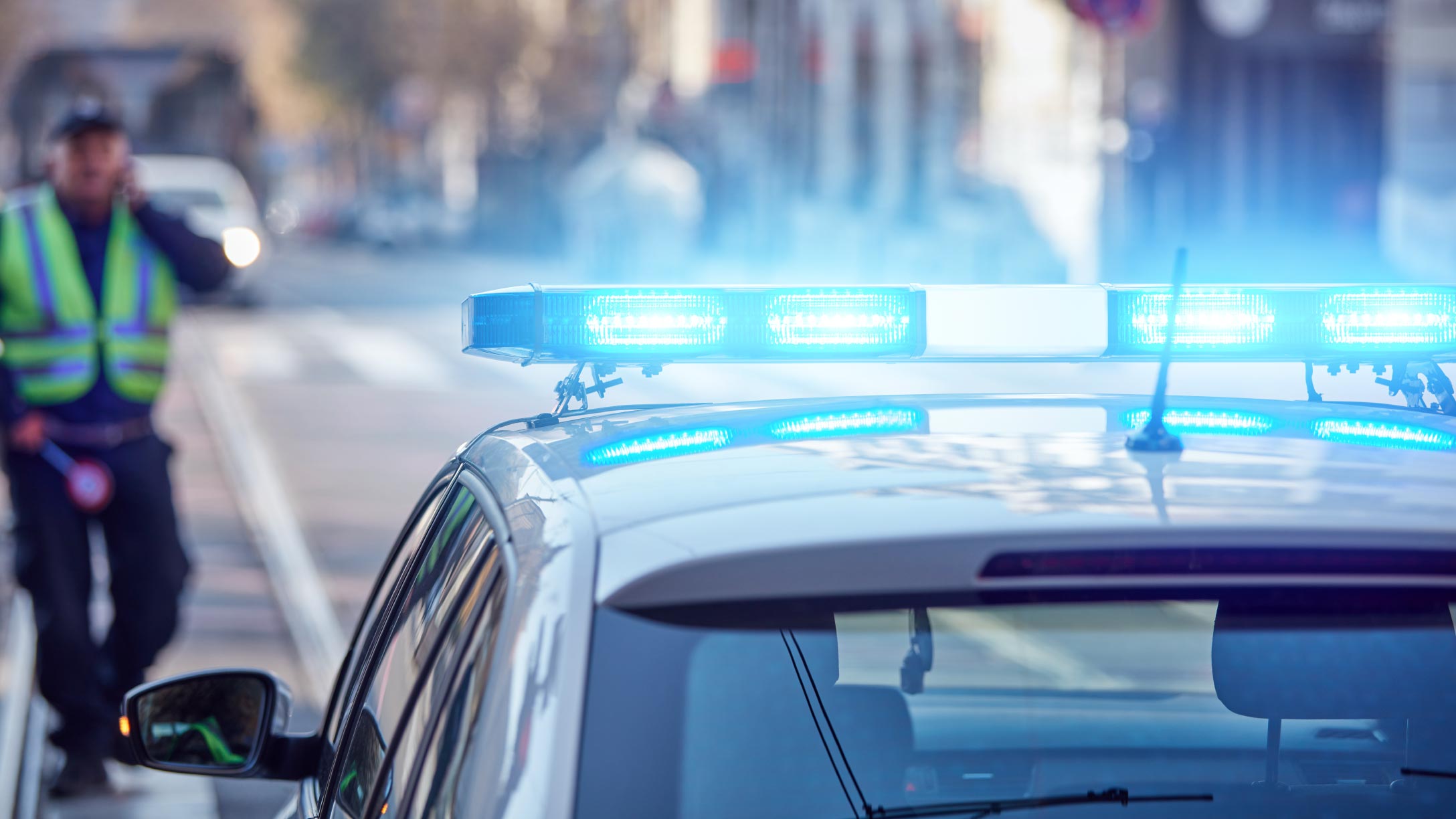 Police car with lights on parked on the side of the road