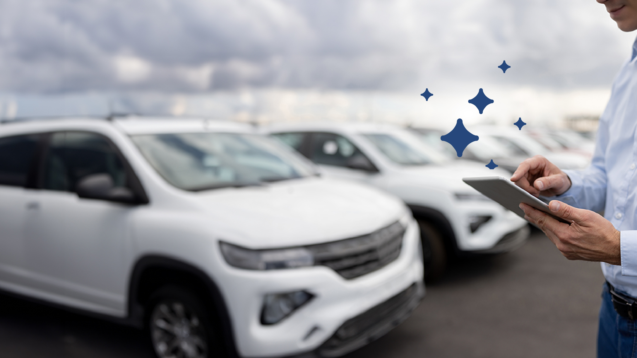 A row of parked cars with person standing in front of them using a tablet