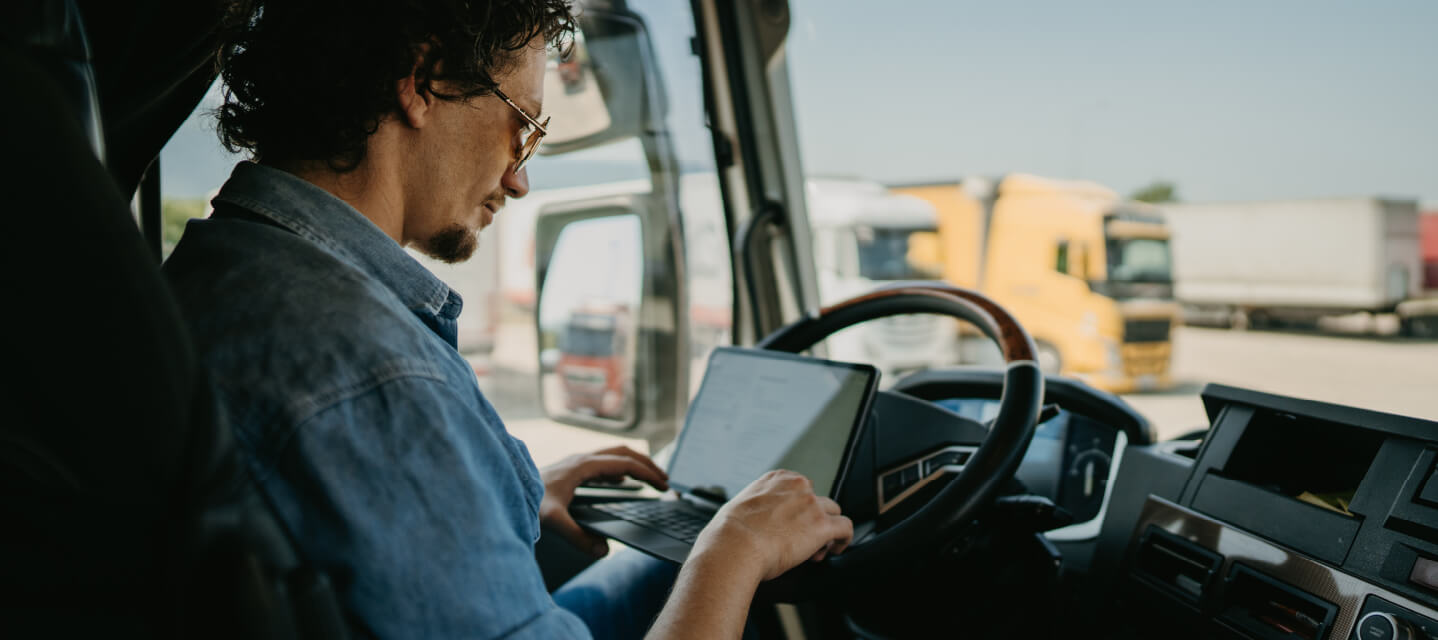 A photo of a truck driver using asset tracking software