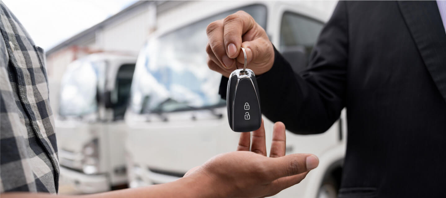 a close up image of someone handing keys to another person.