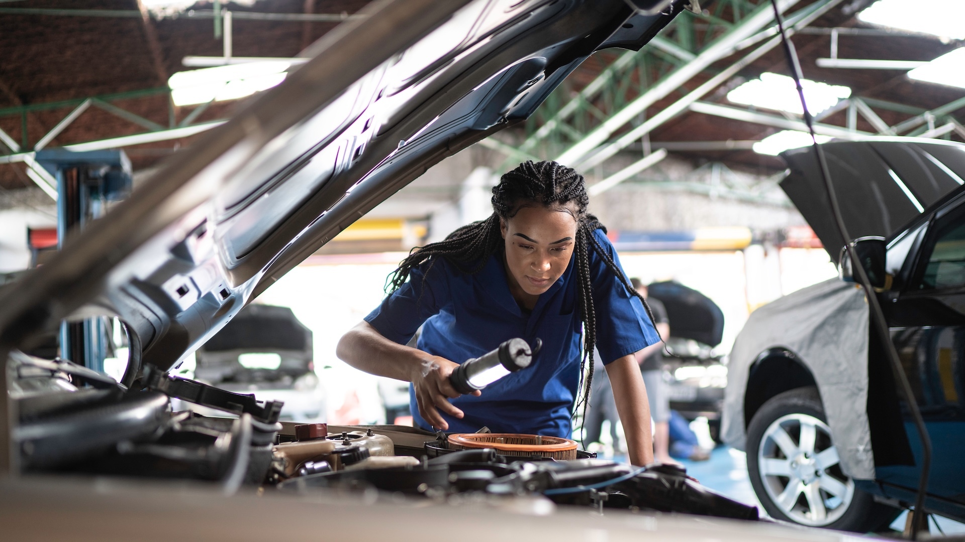woman inspecting a vehicle repair