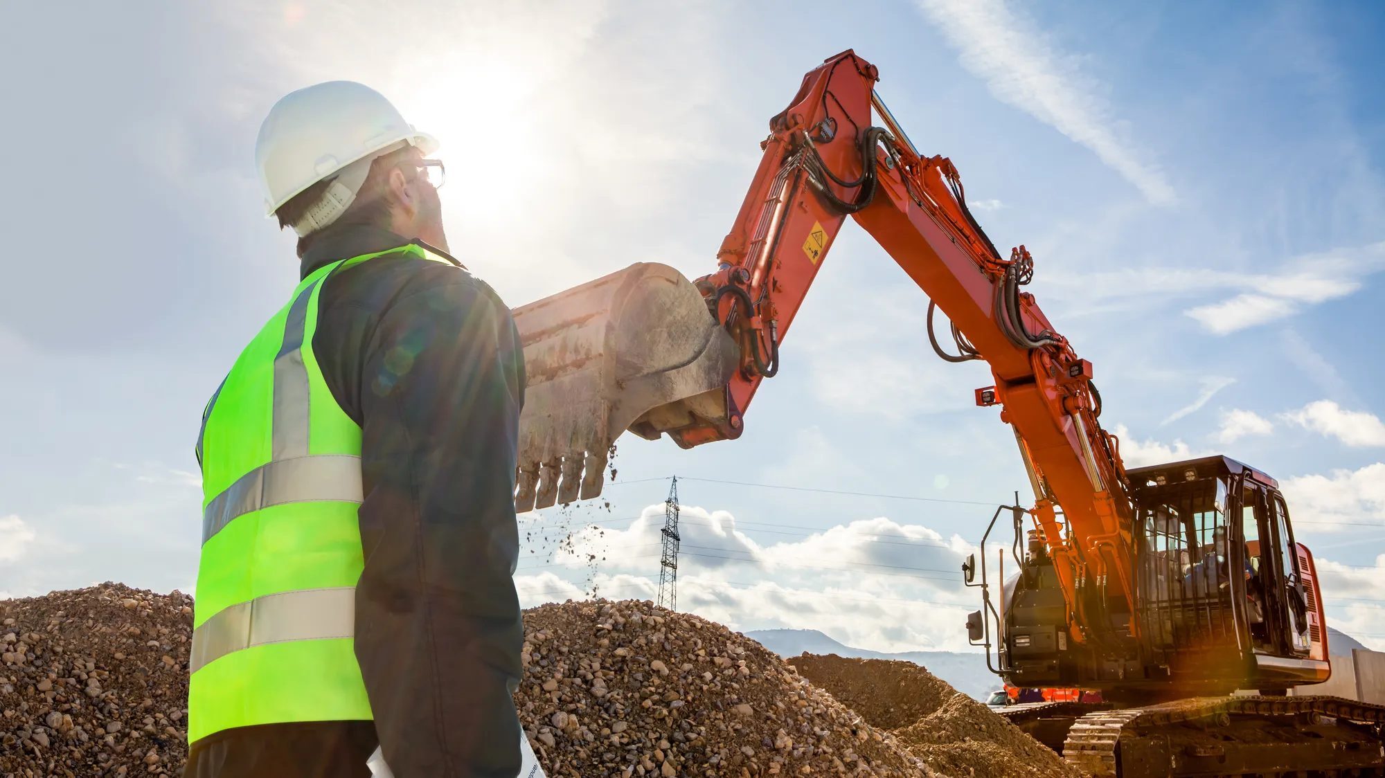 Construction worker operating an excavator on a jobsite.