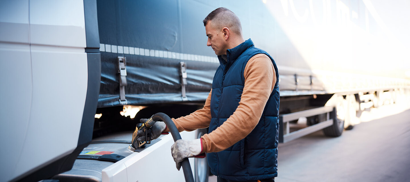 A fleet driver filling a fleet truck with fuel.