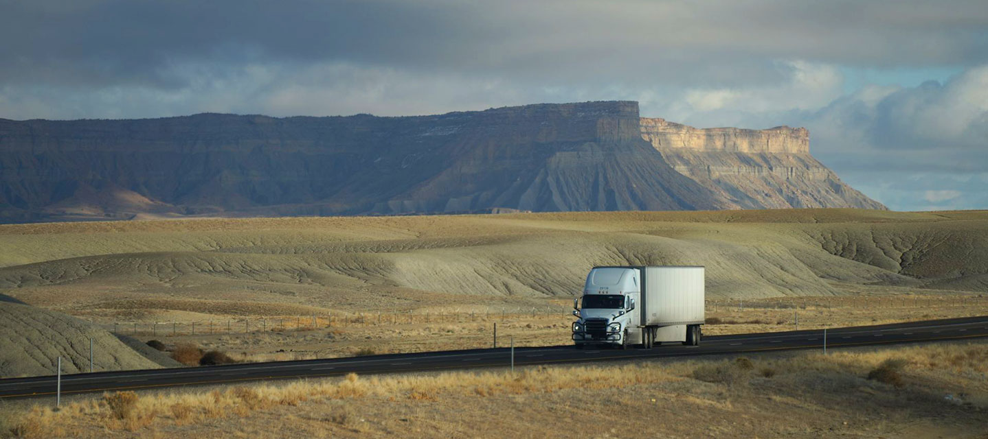 photo of a truck on a long road or something that represents long-distance trucking
