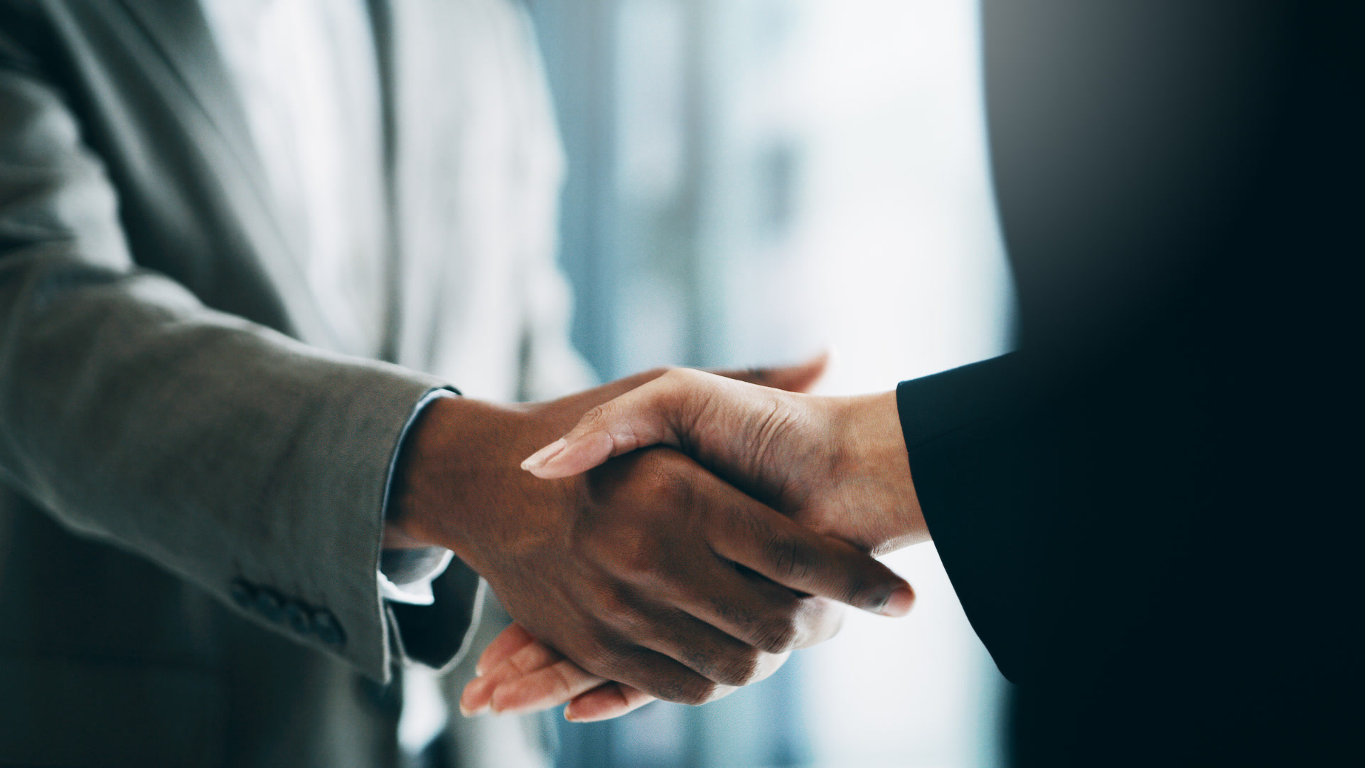 Two professionals shaking hands, representing a broker-carrier agreement following the SCOTUS freight broker liability ruling.