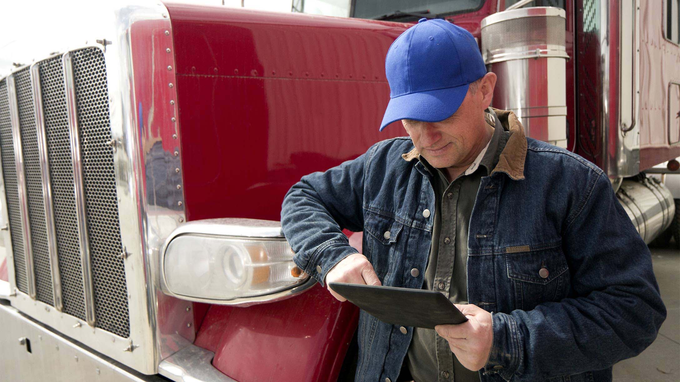 Person standing in front of red truck with a clipboard