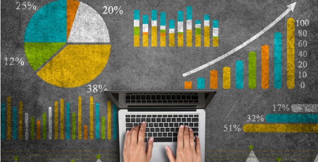 Person using laptop surrounded by chalk data charts