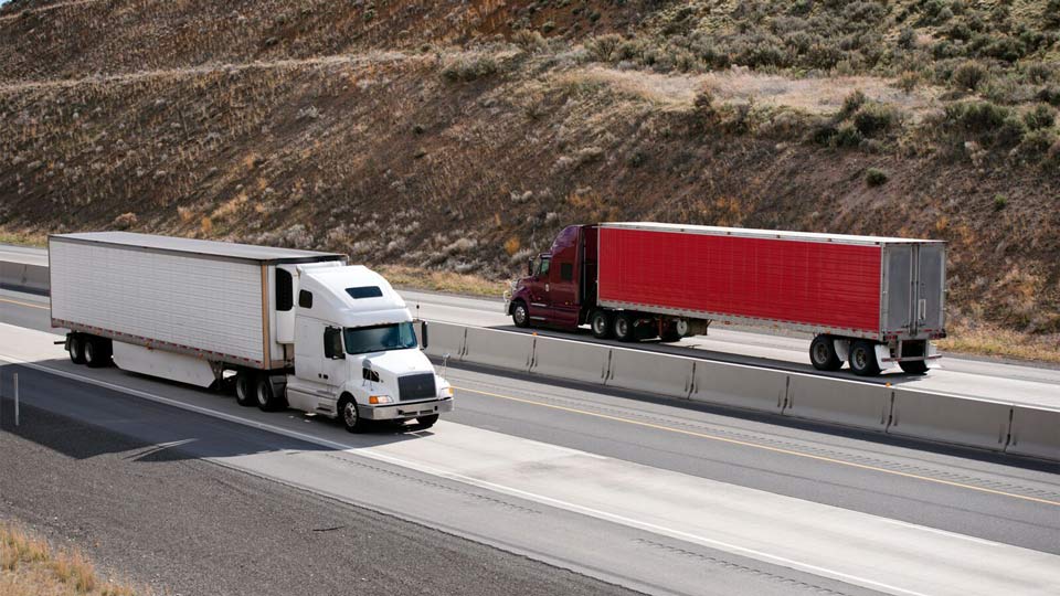 Two semi trucks driving past each other on a road