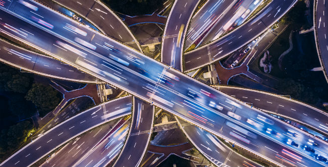 Birds eye view of highways with multiple vehicles driving on them