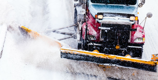 Image of a vehicle with a snow plow plowing snow