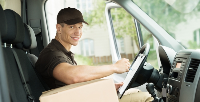 Delivery man with package sitting in a truck