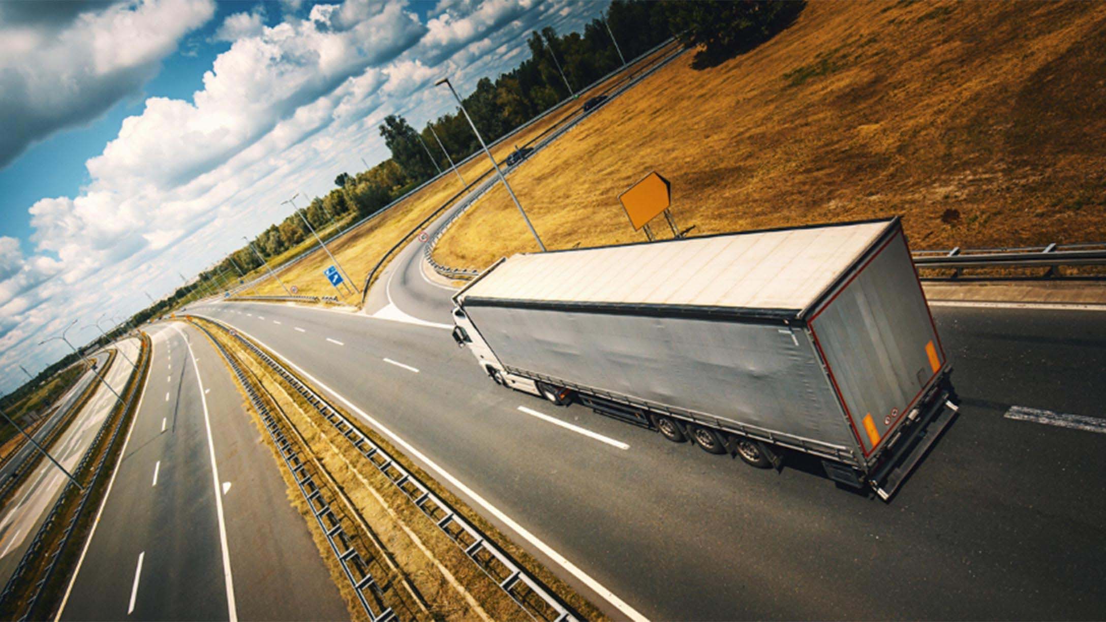 Aerial view of a white truck driving on a road