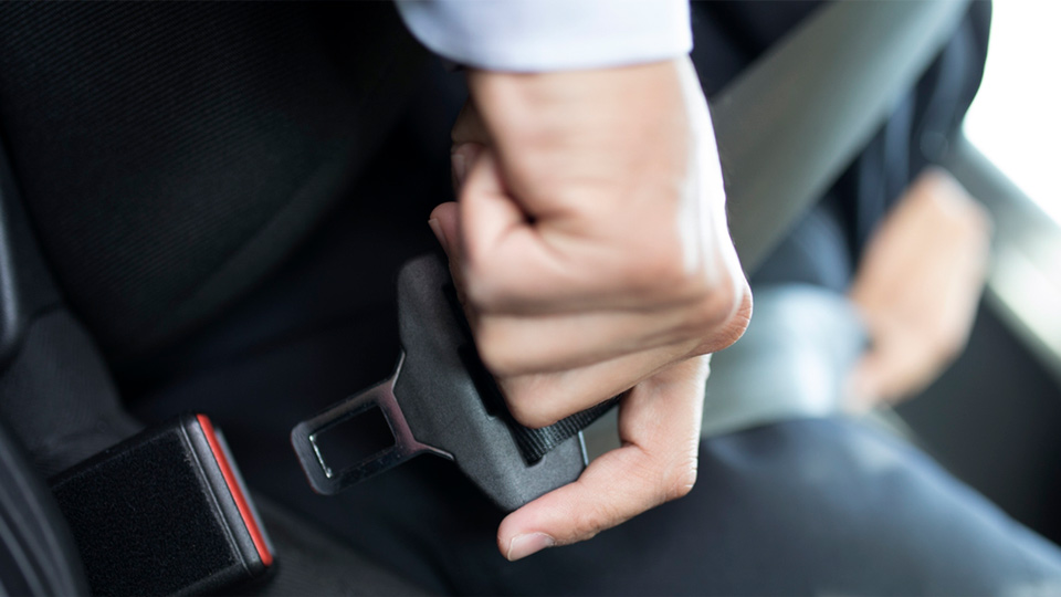 A person buckling their seatbelt