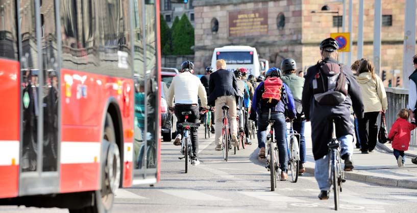 Roter Bus auf der rechten Seite und viele Fahrradfahrer. 