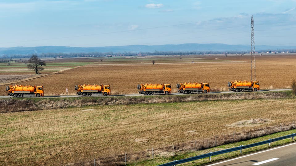 Orange trucks driving on road