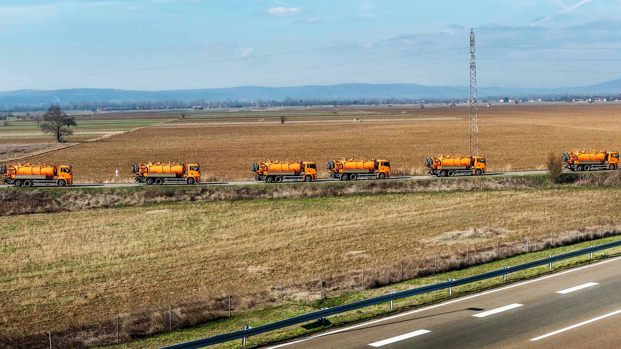 Orange trucks driving on road