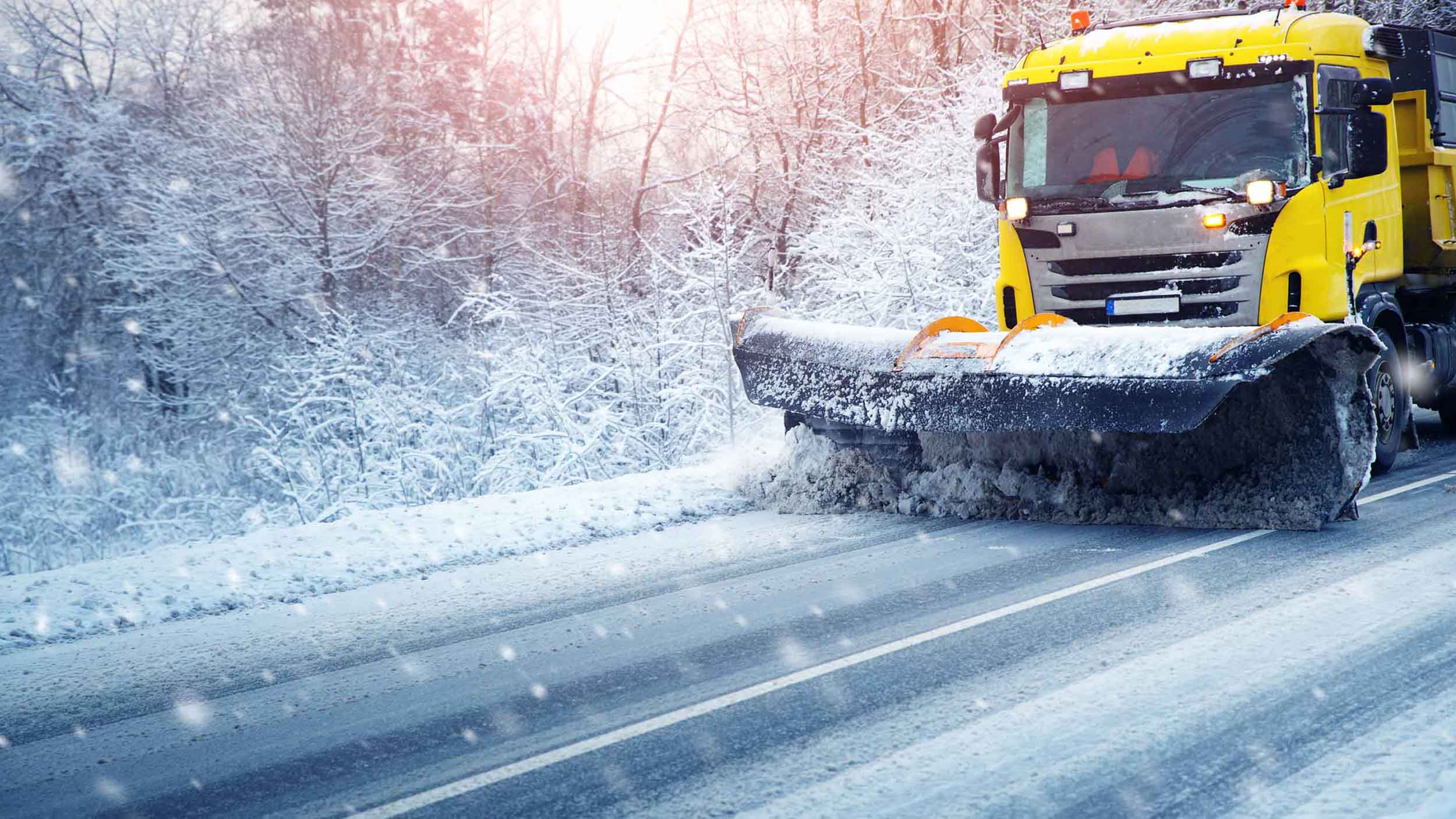 Truck plowing snow off the road