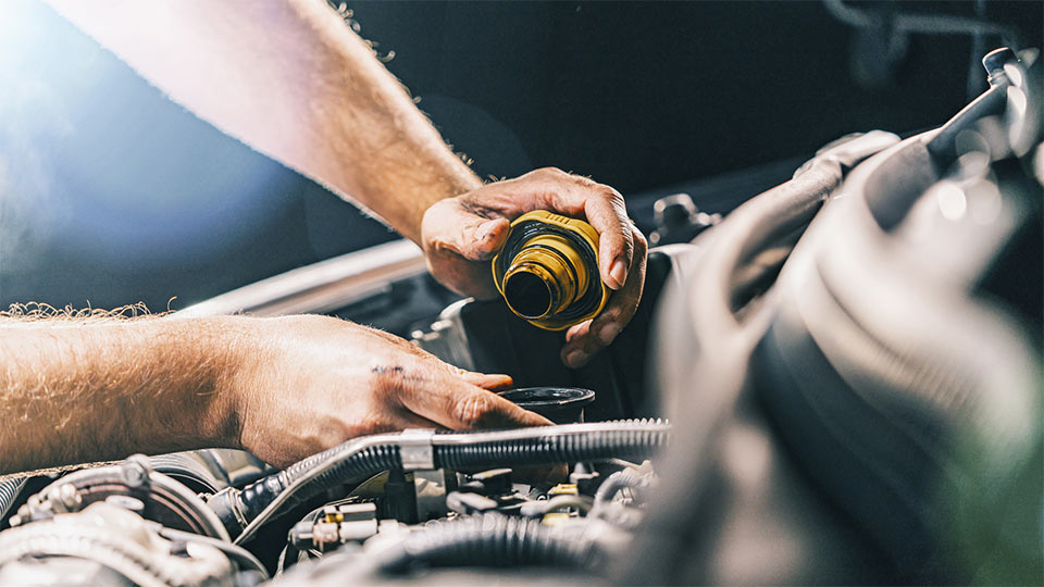 Hands working on a vehicle engine