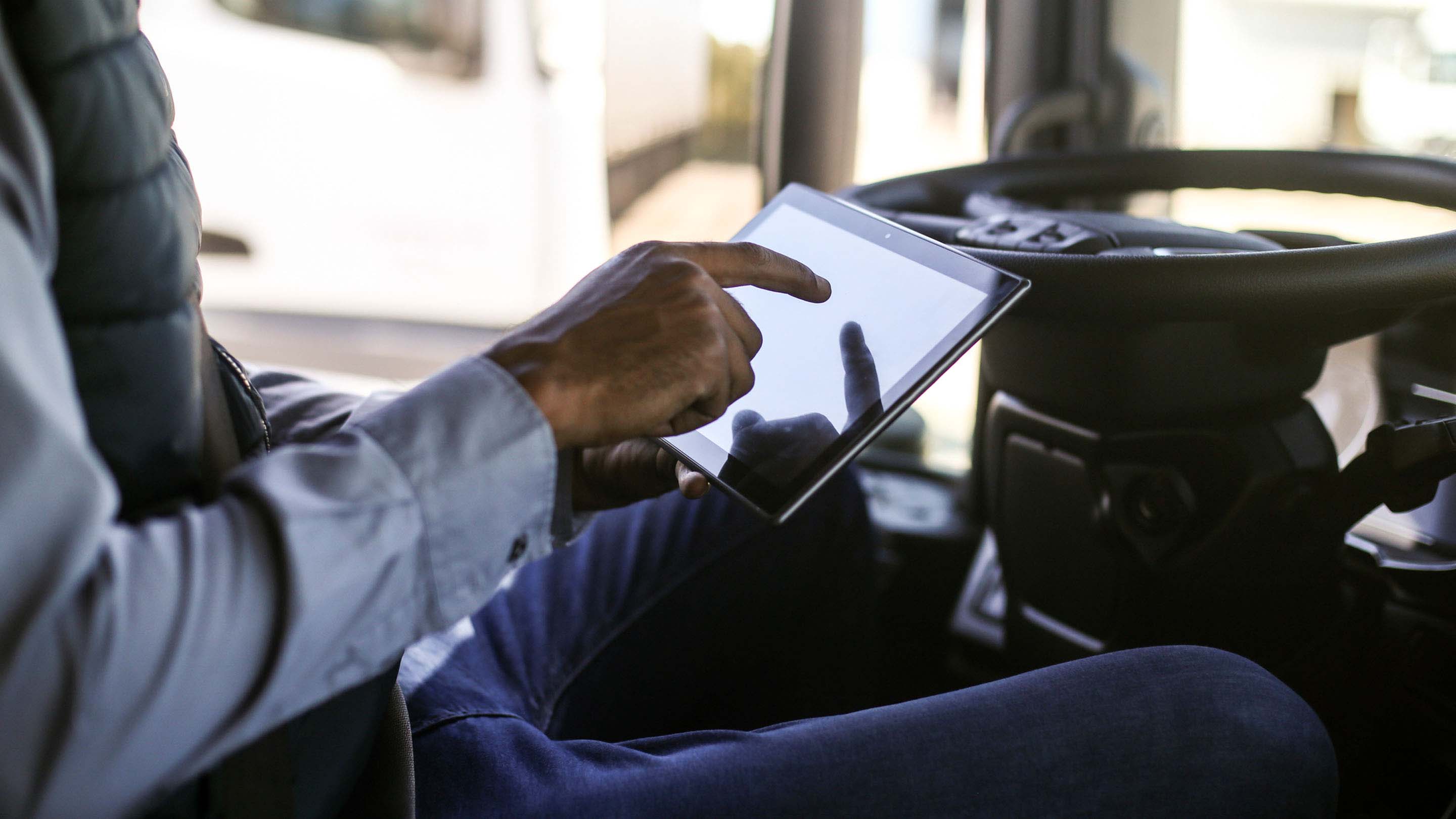 Driver reviewing Hours of Service rules on a tablet in their vehicle