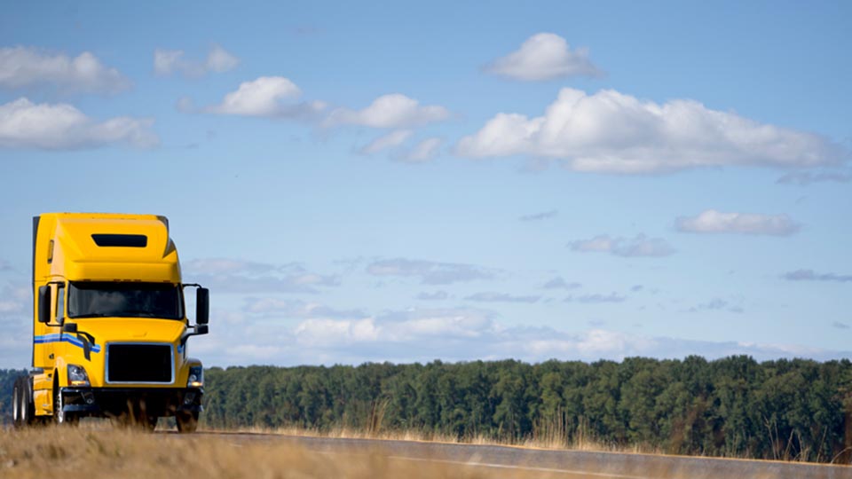 Yellow truck driving on road