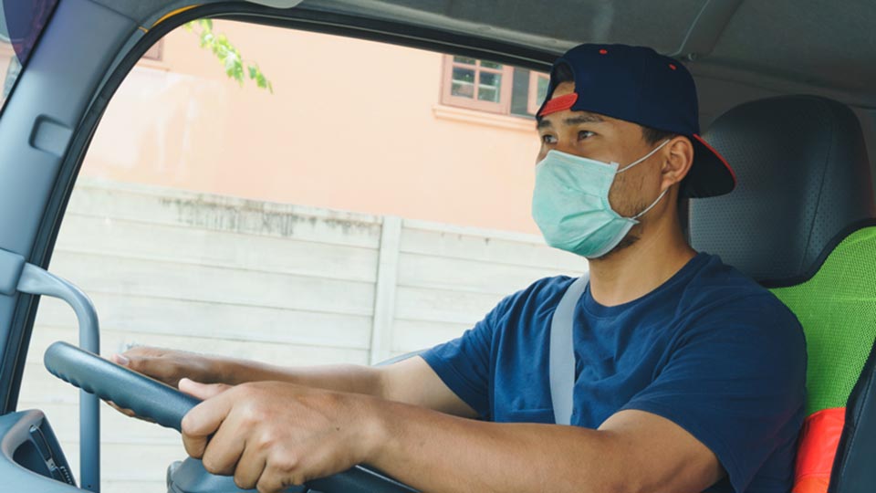 Person driving truck while wearing a mask