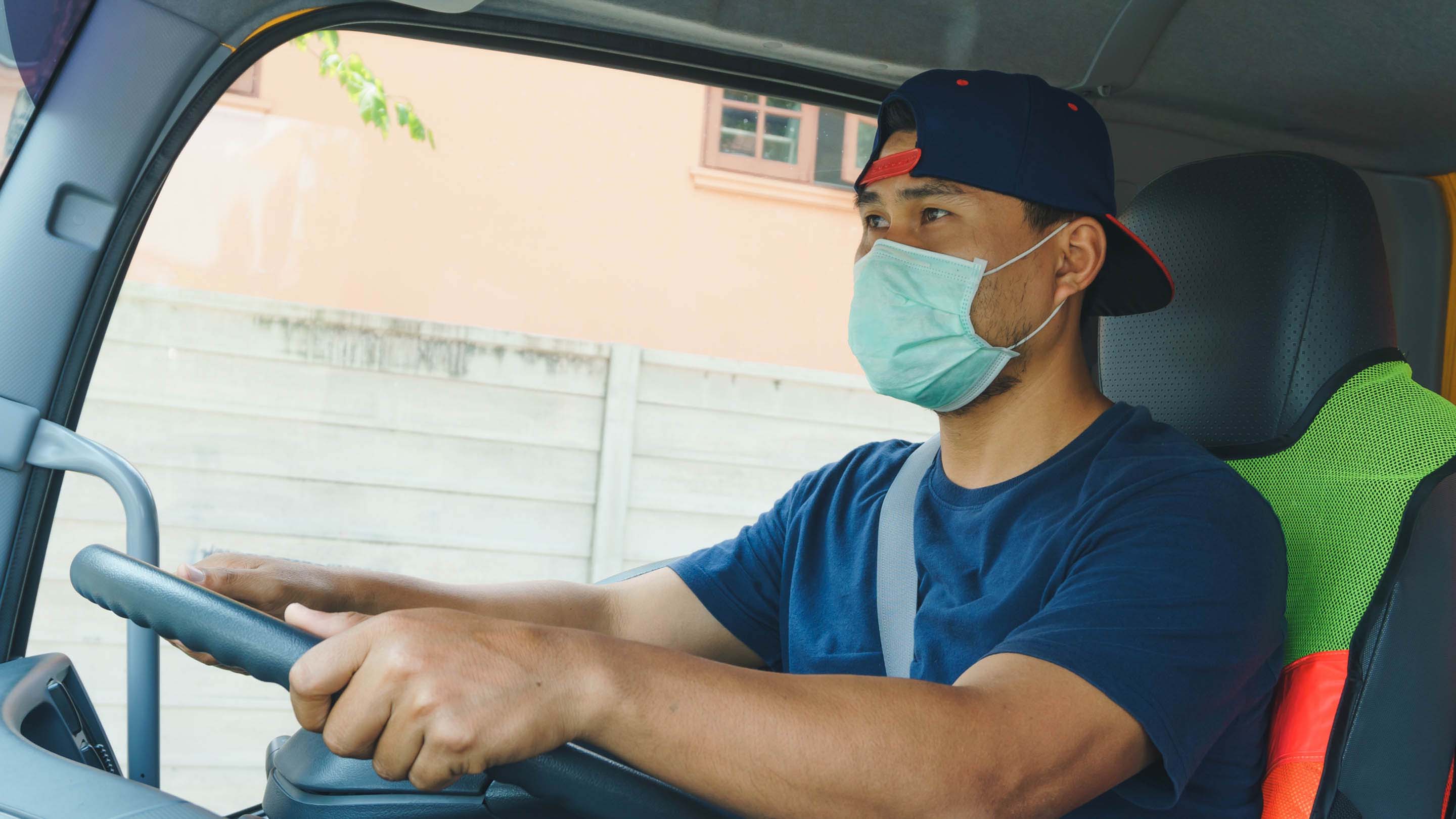 Person driving truck while wearing a mask