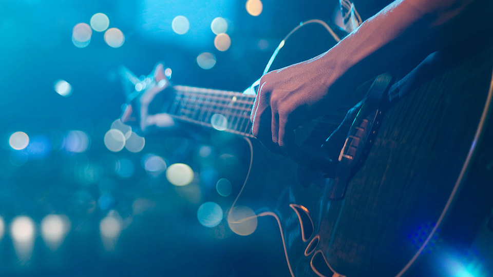 A person playing the guitar on a blue background