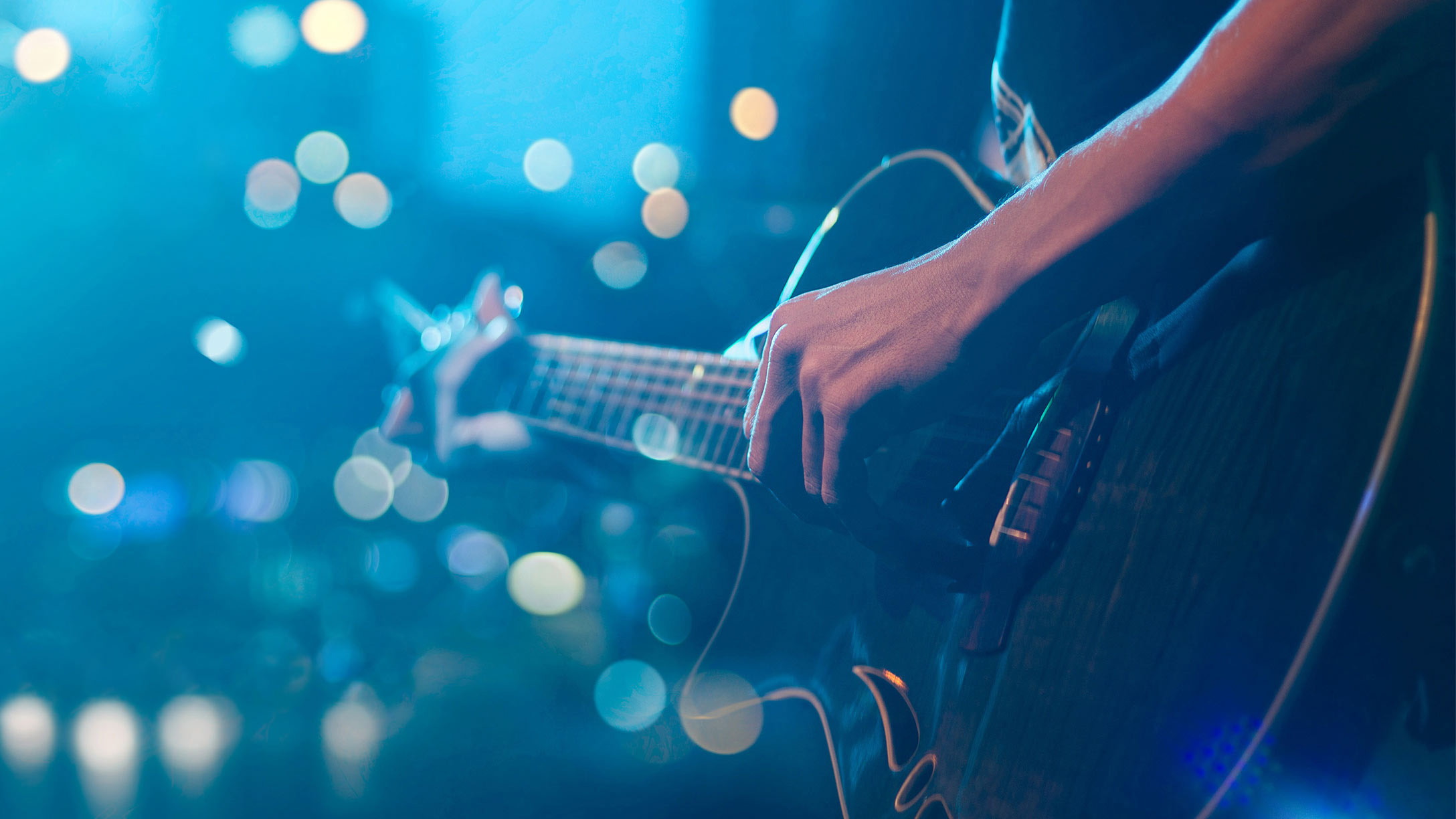 A person playing the guitar on a blue background