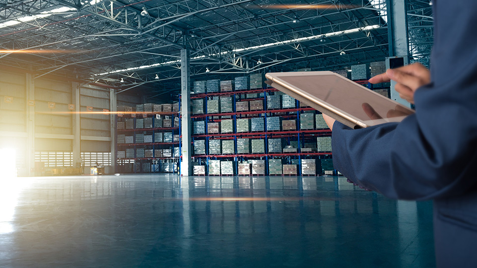 Supply chain manager using a tablet in a warehouse 