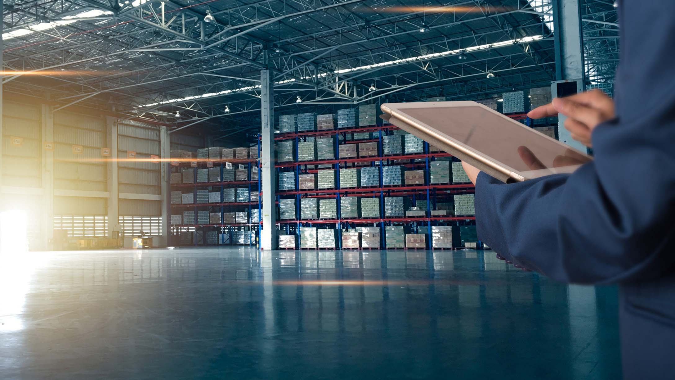 Supply chain manager using a tablet in a warehouse 