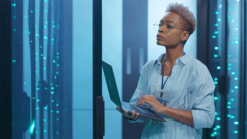 Woman with laptop working in data center with AI