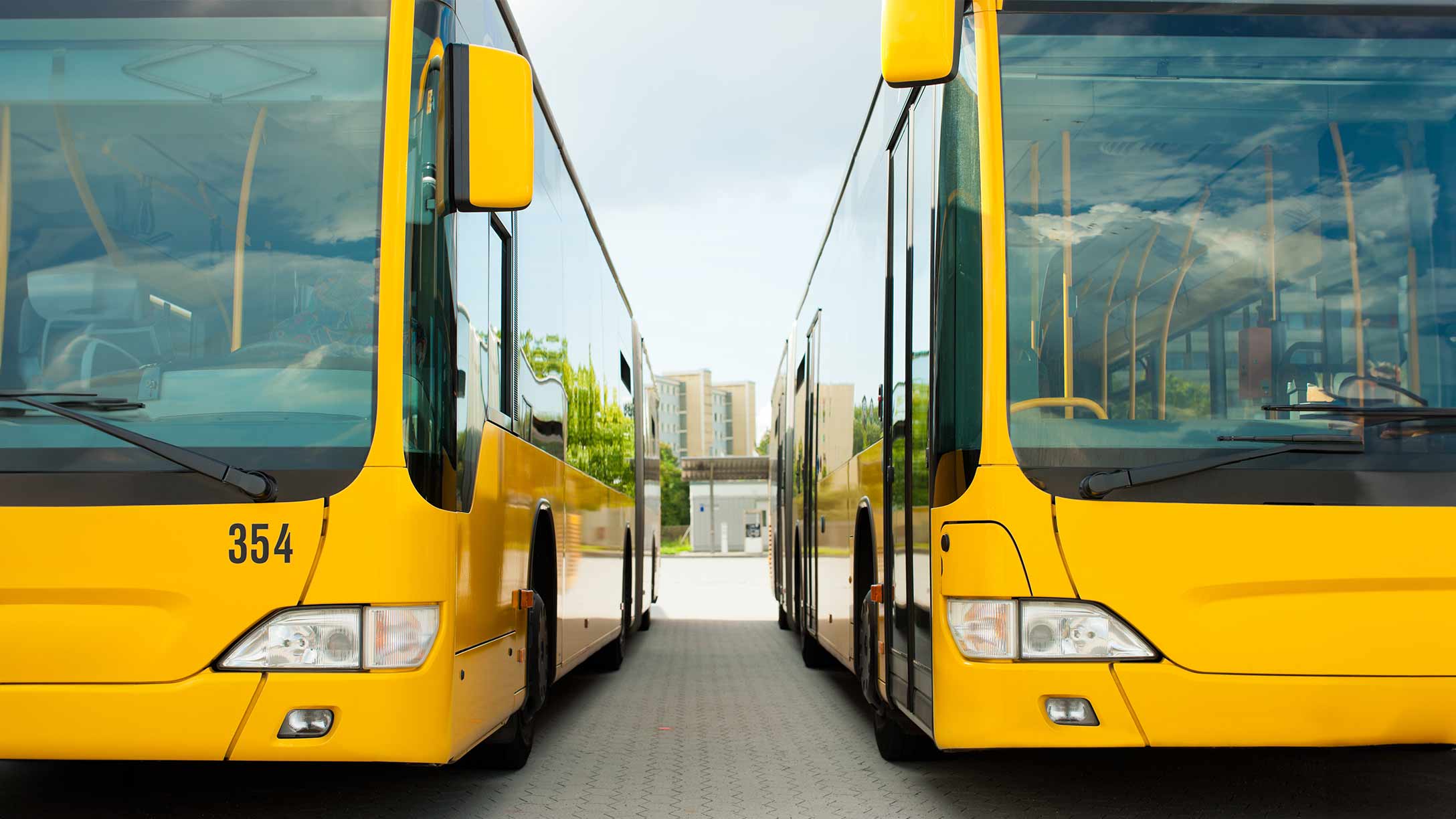 zwei gelbe parkende Busse