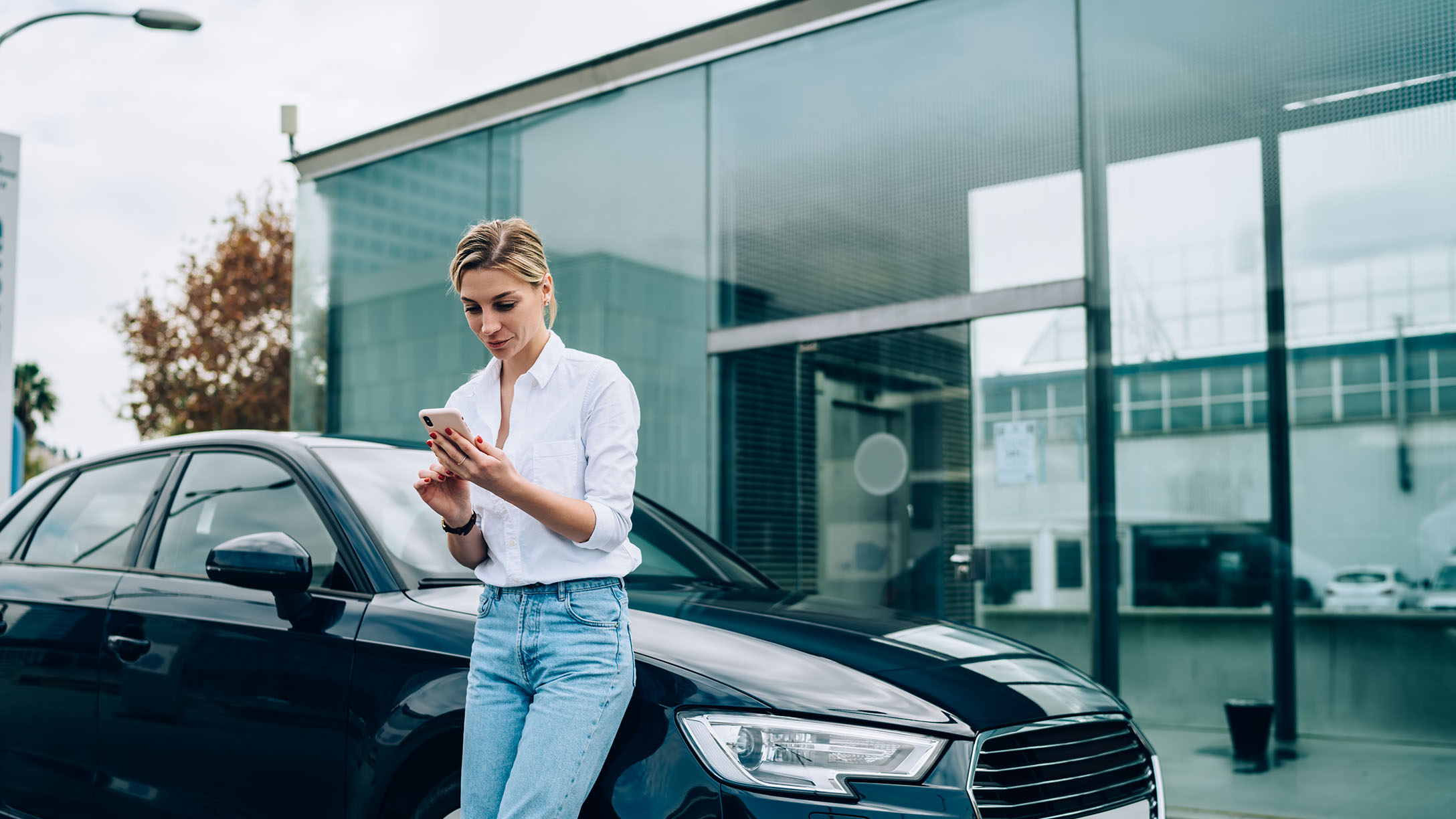 Auto und Mann mit Handy in der Hand. 