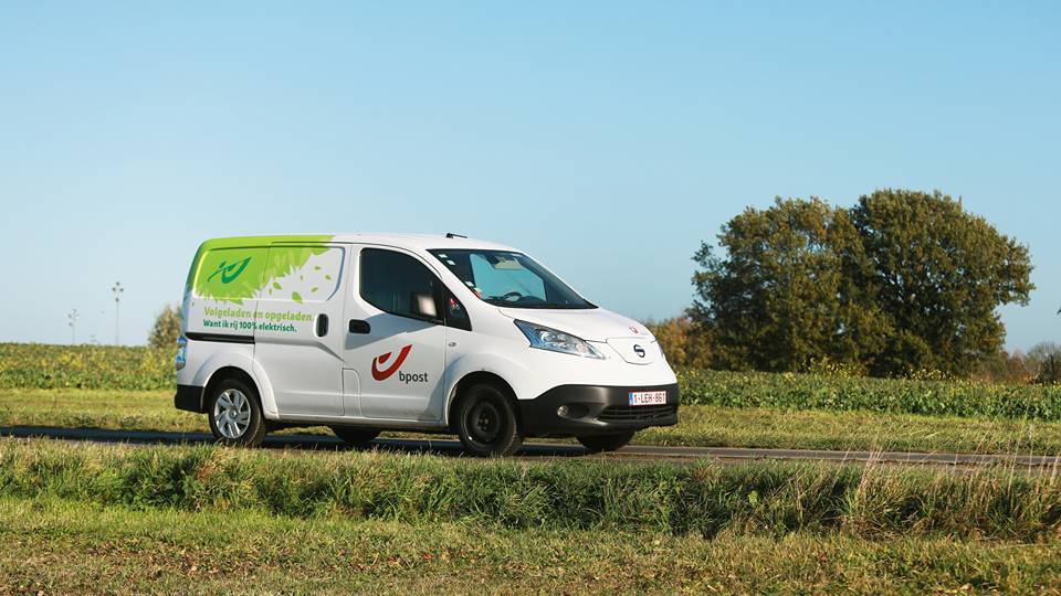 Ein Lieferwagen von bpost auf einer Landstraße.