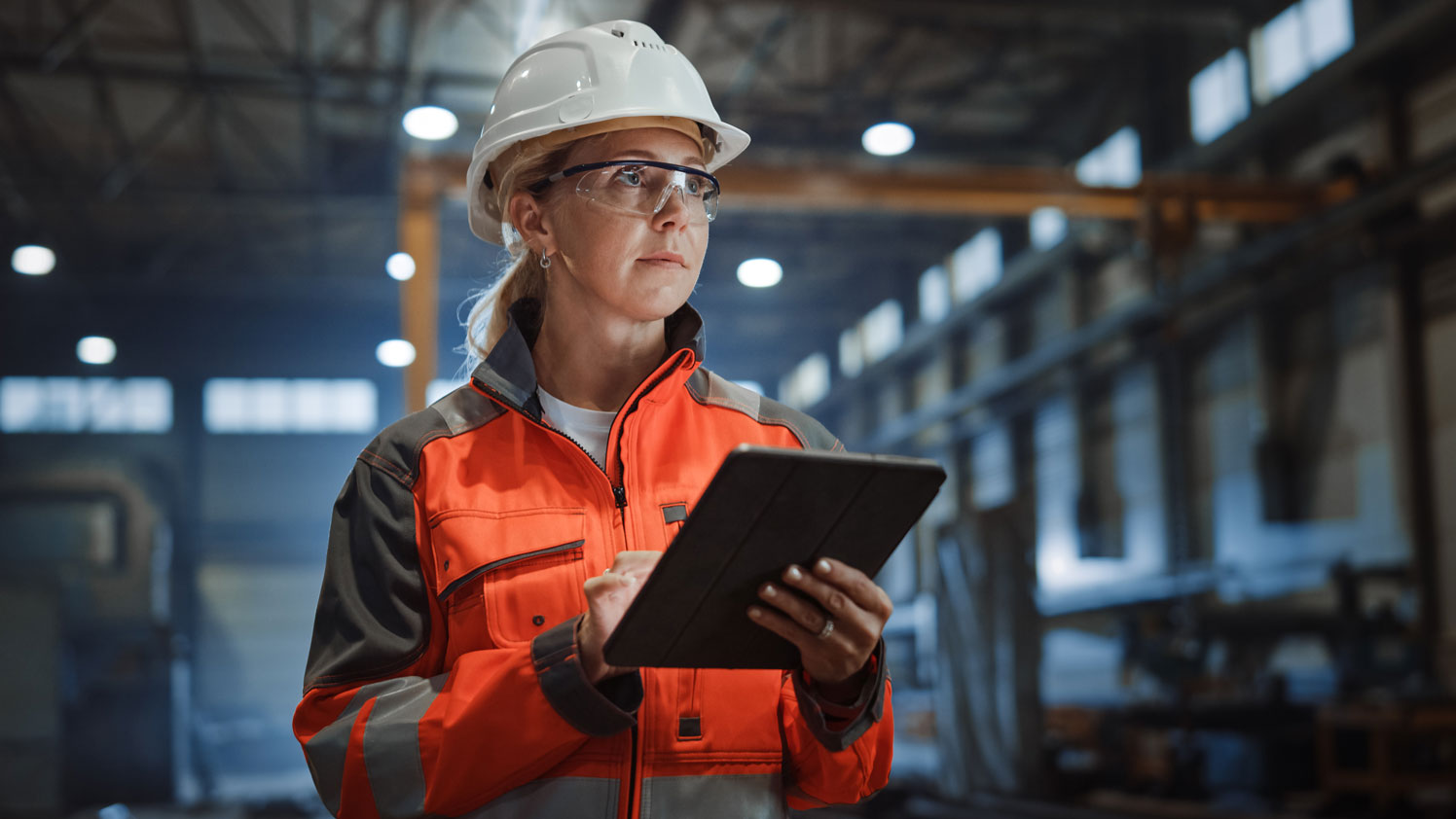 Person in Schutzausrüstung benutzt ein Tablet