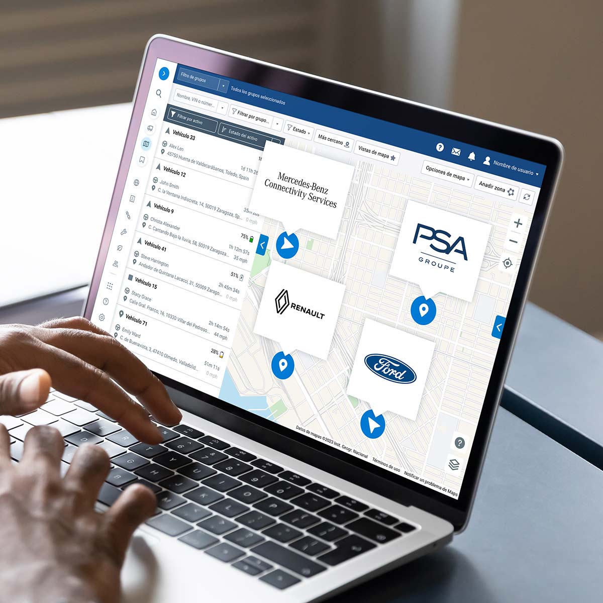 Hombre trabajando en un portátil mostrando la interfaz de usuario del mapa de mygeotab con diferentes logos de OEM