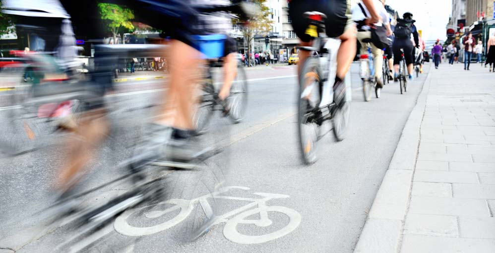 Una colección de ciclistas circulando rápidamente por una ciudad