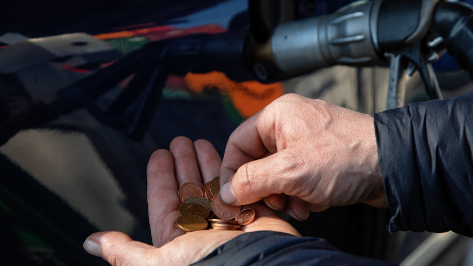 Persona con monedas ahorrando combustible