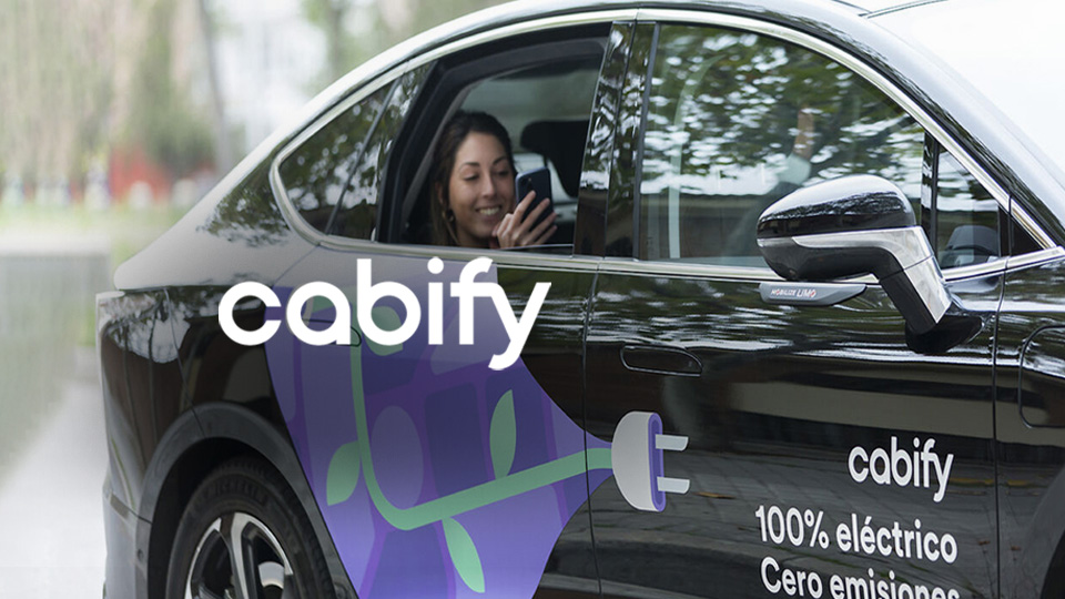 Veicolo nero con logo Cabify e finestrino aperto con una passeggera a bordo