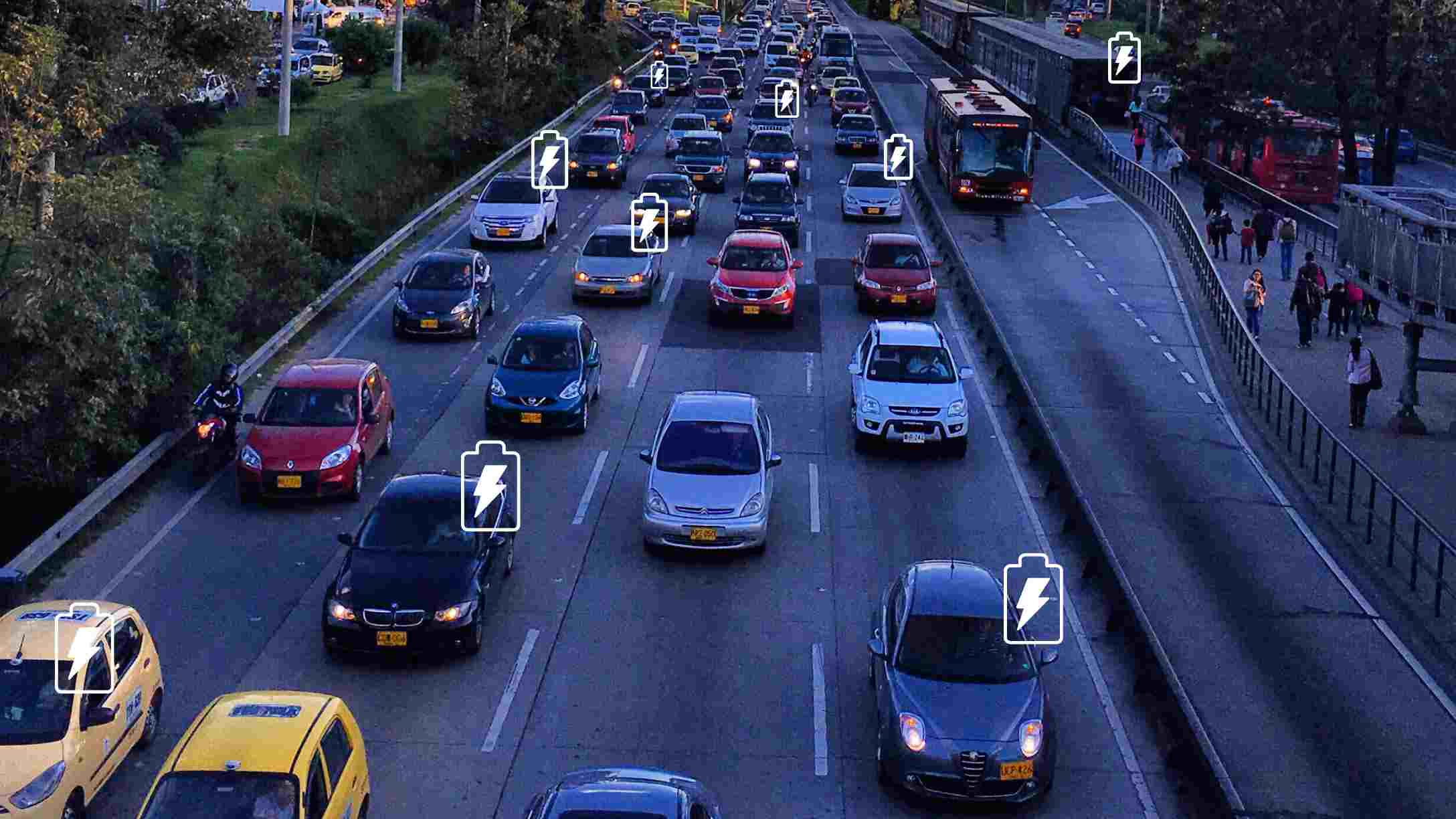 Foto de tráfico en una autopista en Bogotá, con imágenes de baterías eléctricas sobre varios vehículos